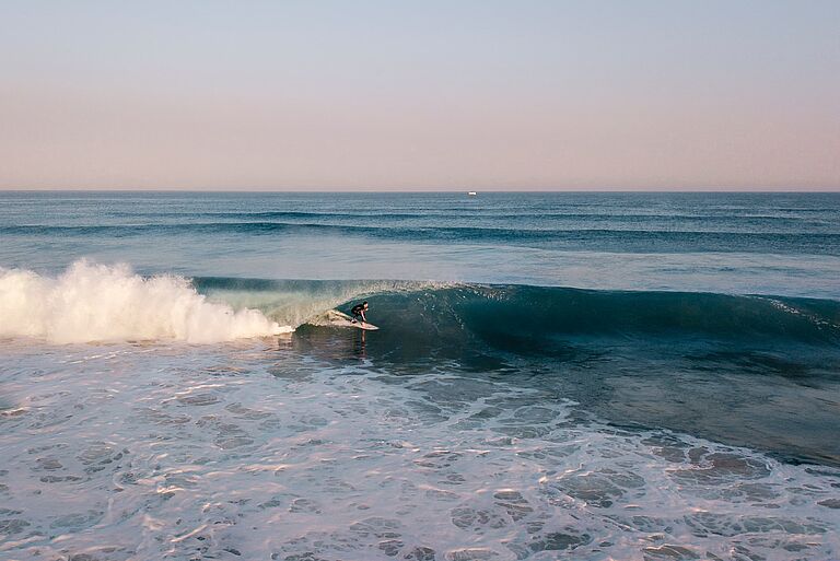 Drohnenaufnahme von Teamrider Alex der eine Welle surft