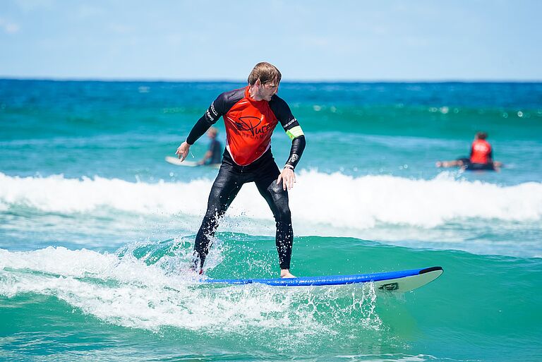 Surfschüler surft Welle
